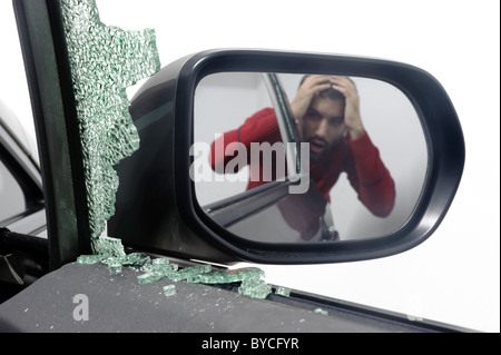 Man despairs with car window glass broken during car theft Stock Photo