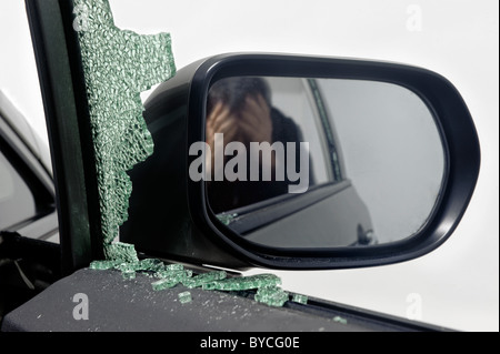 Man despairs with car window broken during car theft Stock Photo