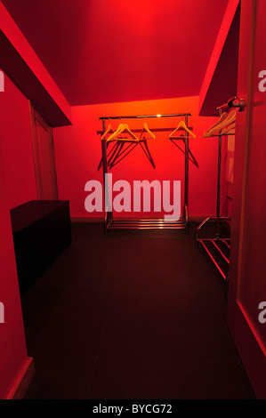 Empty walk in closet with hangers and red walls Stock Photo