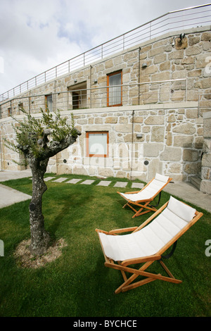 Wooden lounge chairs with white cushion on lawn outside the Casas da Lapa hotel, Lapa dos Dinheiros, Portugal Stock Photo