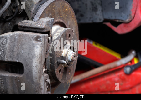 old rusty front brake disc car on a trolley jack for maintenance Stock Photo