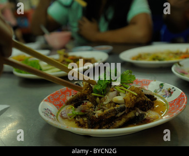 Sun dried Gourami fish Salad , thai seafood speciality , street restaurant , bangkok , thailand Stock Photo