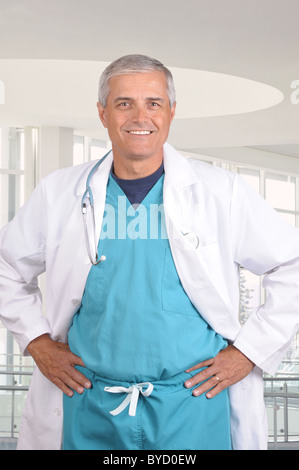 Close up portrait of a smiling middle aged doctor in scrubs with stethoscope around his neck. Stock Photo