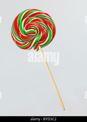 Red and green colored lollipop on a stick isolated on white background