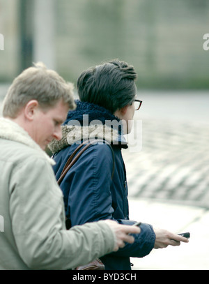 Two men in the street using their mobile phones, not paying attention to one another Stock Photo