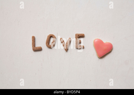 Love, word written with biscuits, with a heart-shaped biscuit Stock Photo