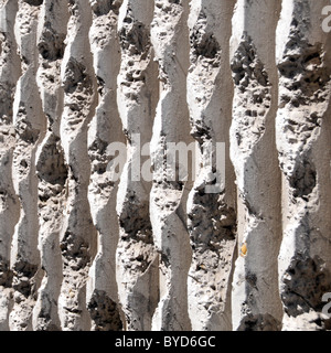 White vertical corrugated texture in precast concrete building wall panel engrained black speckles as abstract pattern background image England UK Stock Photo