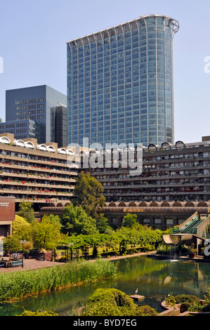 City of London Barbican water garden around homes in apartment blocks of flats and high rise office tower block beyond in urban landscape England UK Stock Photo