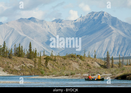 Canoeists on the Wind River, canoeing, paddling a canoe, Northern Mackenzie Mountains behind, Yukon Territory, Canada Stock Photo