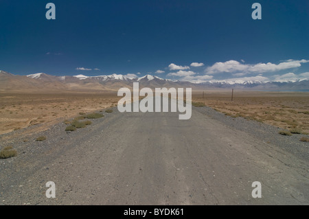 Country road leading through wilderness, Karakul, Pamir Mountains, Tajikistan, Central Asia Stock Photo