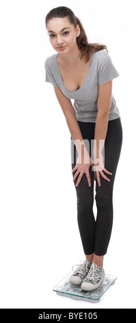 Teenager standing on scales. Isolated on a white background. Stock Photo