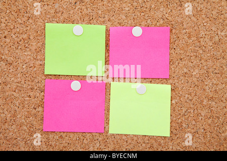 Blank sticky notes pinned on cork memo board in closeup Stock Photo