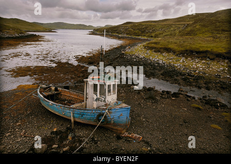 Old fishing boat abandoned on the shore of Loch Eireasort, Isle of Lewis, Outer Hebrides, Scotland, UK Stock Photo