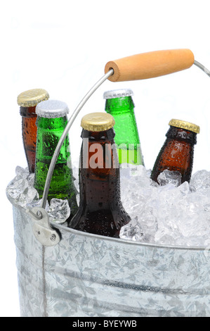 Closeup of a bucket filled with ice cubes and an assorted beer bottles on a white background. Stock Photo