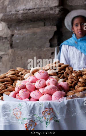 A Peruvian woman stands by a street stall of sweets and biscuits during a weekend fair in the main saquare of Ayacucho. Stock Photo