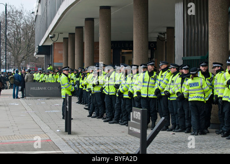 Long line police officers protecting Conservative HQ Millbank Centre from student and teacher protesters on education cuts march Stock Photo