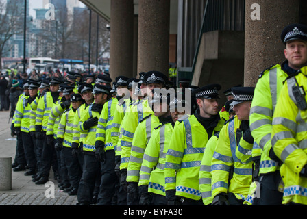 Long line police officers protecting Conservative HQ Millbank Centre from student and teacher protesters on education cuts march Stock Photo