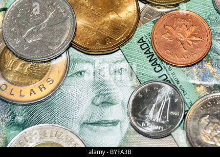 Canadian money: twenty dollar bill showing the queen's face surrounded by coins. Stock Photo