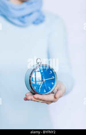 Woman holding alarm clock Stock Photo