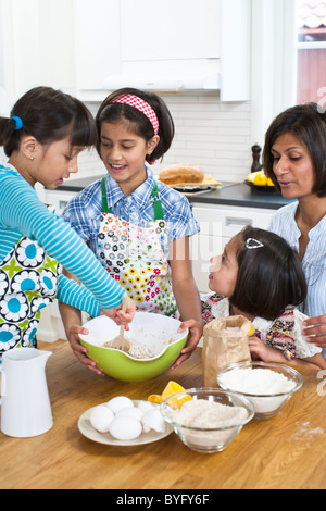 Mother baking with girls in kitchen Stock Photo