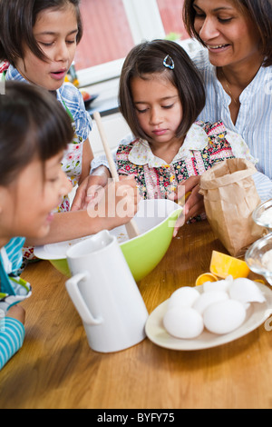 Mother baking with girls in kitchen Stock Photo