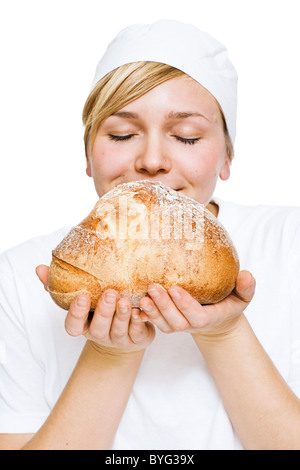 Woman smelling fresh loaf of bread Stock Photo