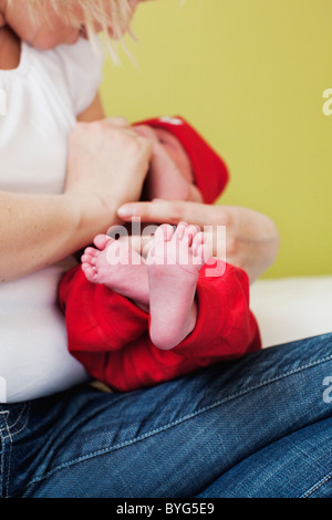 Mid adult woman holding newborn child Stock Photo