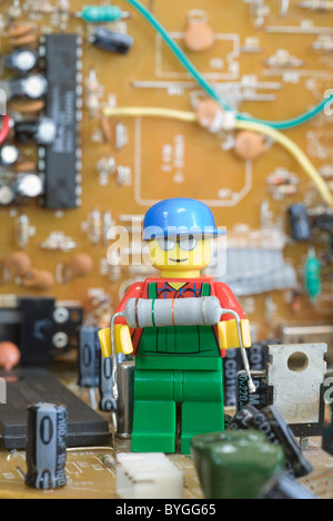 Lego technician in electronic land holding a resistor electronic component. Stock Photo