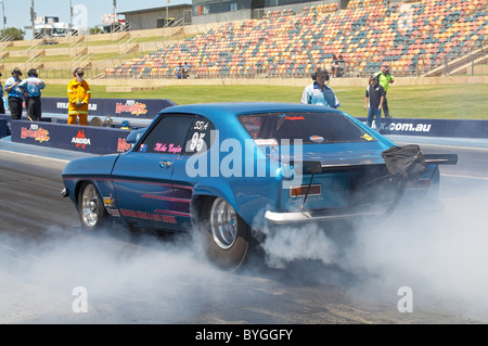 Drag racing Ford Capri performing a burnout to warm the tires before racing on the quarter mile drag strip Stock Photo