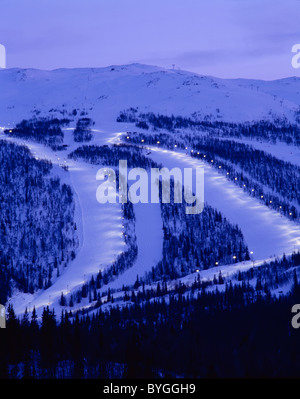 Snow covered mountains and ski slope at dusk Stock Photo