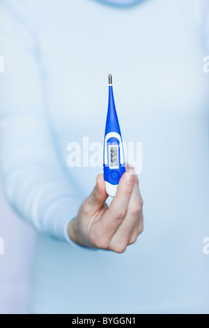 Woman holding thermometer Stock Photo