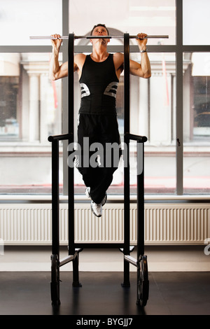 Male athlete doing pull ups in gym Stock Photo