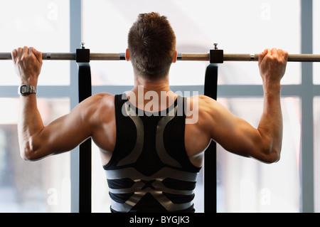 Male athlete doing pull ups in gym Stock Photo