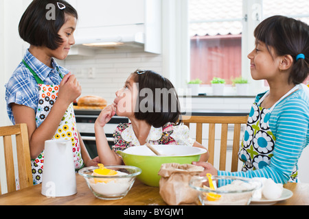 Three girls baking in kitchen Stock Photo