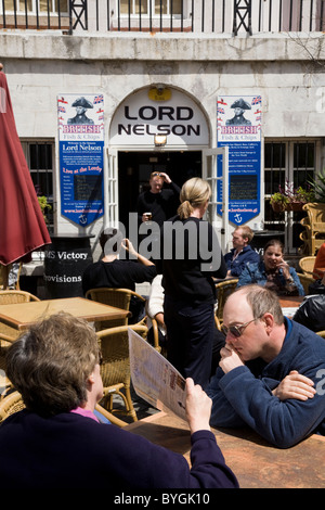 People choosing meals / food / drink from menu at outdoor restaurant tables outside The Lord Nelson Bar Brasserie pub. Gibraltar Stock Photo