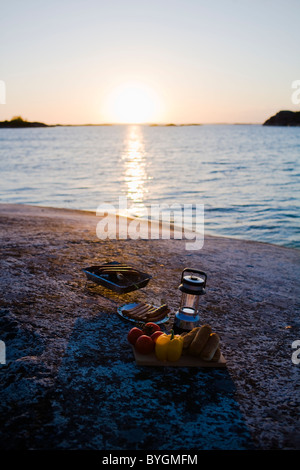 Barbecue equipment by sea at sunset Stock Photo