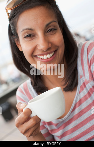 Portrait of woman holding coffee cup outdoors Stock Photo
