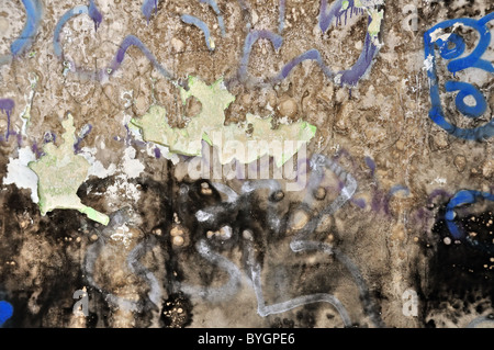 Old peeling grunge wall covered with messy graffiti and mold. Background texture. Stock Photo