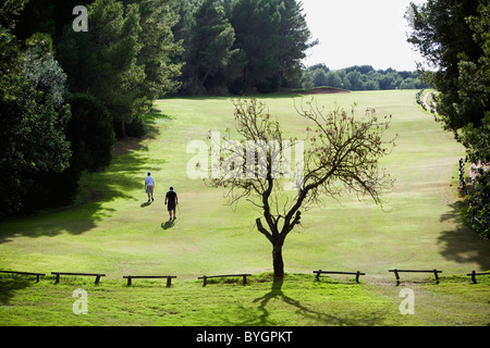 Two golfers walking on golf course Stock Photo