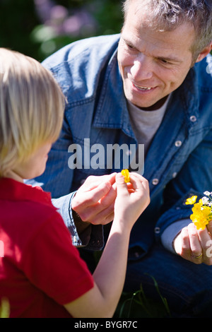 Father and son with flowers in bright sunlight Stock Photo