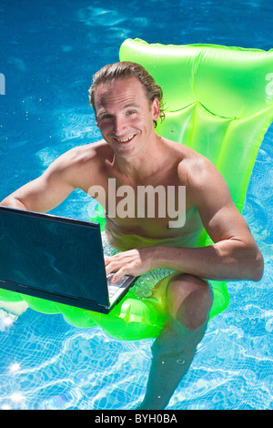 Man on inflatable raft in swimming pool Stock Photo - Alamy