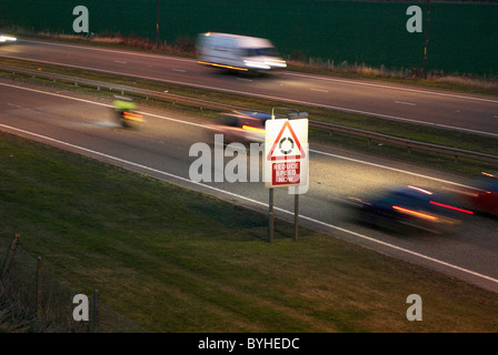 Roundabout Reduce Speed sign on dual carriageway Kent UK (blurred motion) Stock Photo