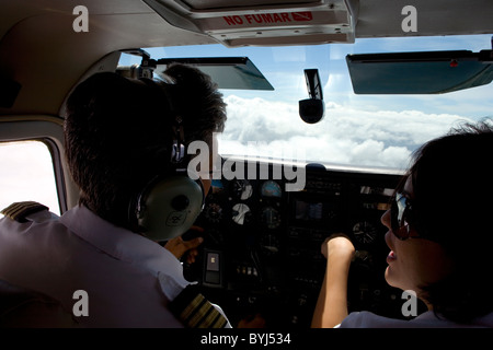 Man Pilot And Woman Tourist Talking In Chesna Type Airoplanes Cockpit While Flying Above The Clouds Stock Photo