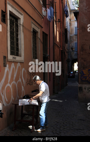 A man reading a newspaper in the street, Rome, Italy Stock Photo