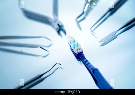 Toothbrush surrounded by dental instruments with very shallow depth of field Stock Photo