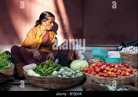 Indian woman selling vegetables at a local india market in the town of Puttaparthi. Andhra Pradesh, India Stock Photo