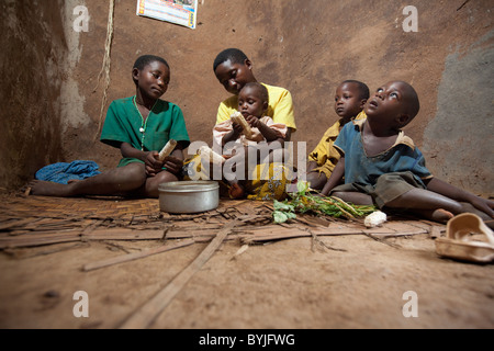 A family shares a meal together in their mud home in Masaka, Uganda, East Africa. Stock Photo