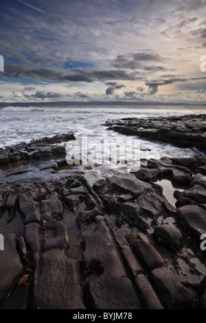 Looking out from the rocky shoreline at Nash Point towards the Gower Peninsula on the Glamorgan Heritage Coastline in Wales. Stock Photo