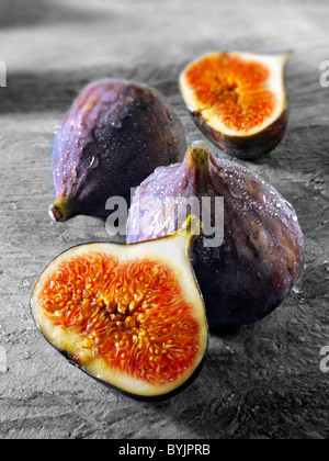 Close up of fresh whole & cut figs on a table setting Stock Photo