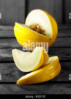 Fresh cut honeydew melons on a table setting in a kitchen Stock Photo